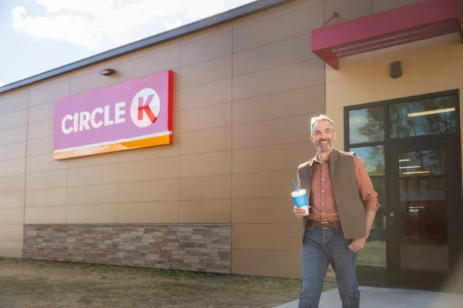 man leaving Circle K with drink in hand